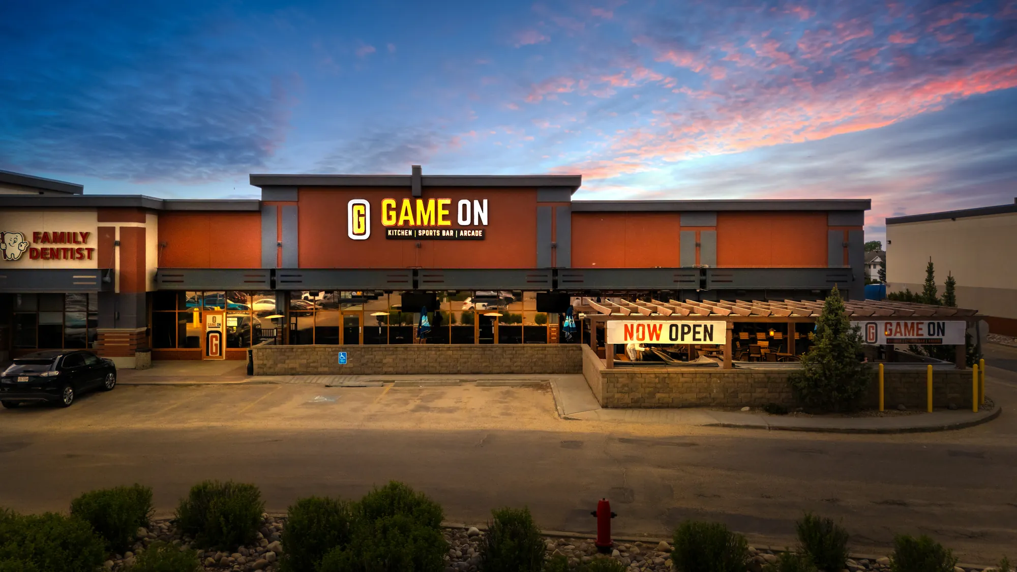 Game On from the parking lot at dusk, the sign lit and the patio open